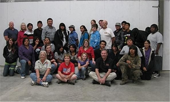 A group of people sitting in front of a wall.