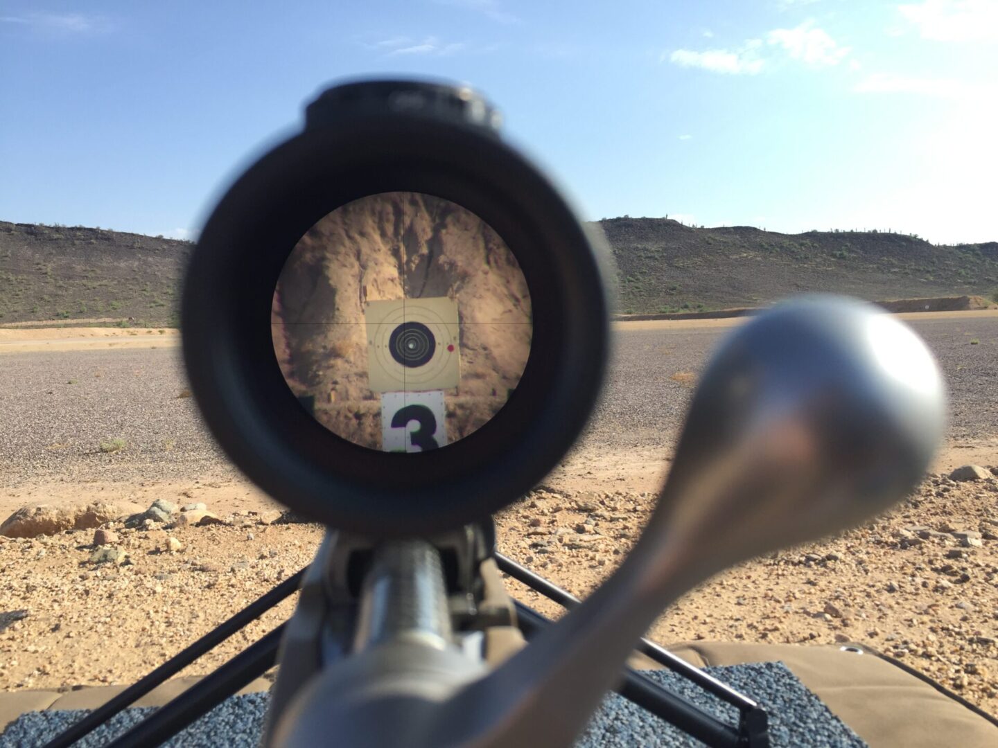 A rifle scope with the sight of a target in it.